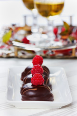 chocolate cake decorated with raspberries in white plate