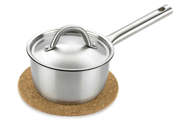 Stainless steel saucepan over cork trivet isolated on white
