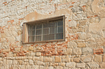 Fototapeta na wymiar Old stone wall with fallen