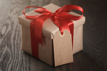 rustic gift box with red ribbon bow and empty tag