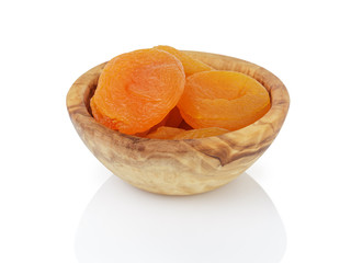 heap of dried apricots in wood bowl