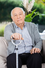 Portrait Of Elderly Man Holding Metal Walking Stick