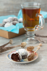 Chocolate cookies in powdered sugar with tea and caramel sugar