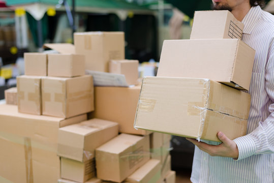 strong man holding, moving 3 boxes in the warehouse