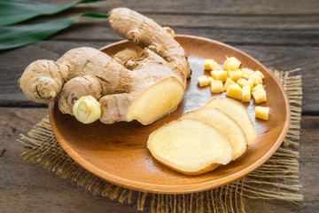 Ginger root sliced on wooden plate