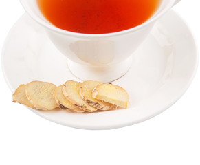 Ginger slices and a cup of tea over white background