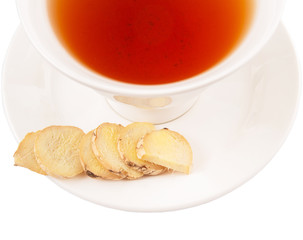 Ginger slices and a cup of tea over white background