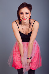 Elegant brunette girl with earrings in pink and black dress