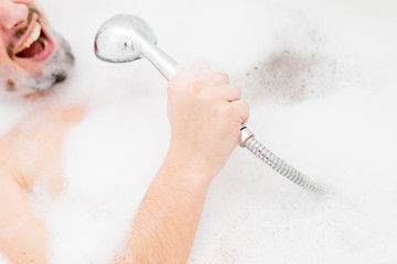 man singing in bath with foam