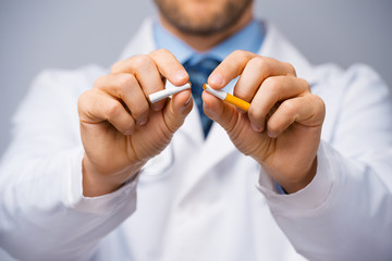 Doctor breaking a cigarette