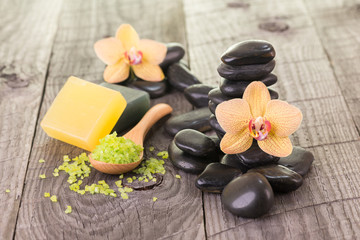 Yellow Moth orchids and black stones on weathered deck