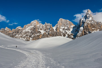 Fototapeta na wymiar Hiker heading the Pale mountains in the snow, Dolomites