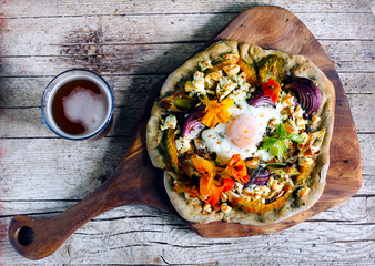 Pizza with root vegetables, cottage cheese, egg and flowers