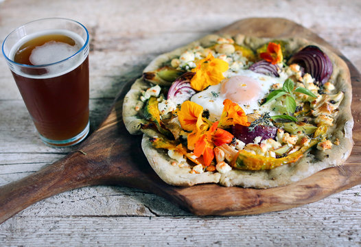 Root vegetables pizza with cottage cheese, egg and flowers