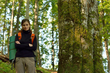 Calm young girl tourist with backpack and sleeping mat