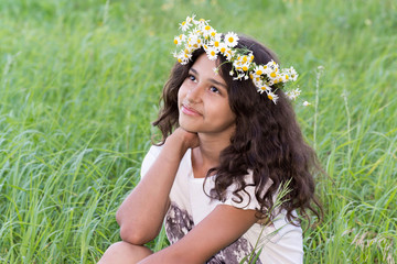 teenage girl with a wreath of daisies on the nature