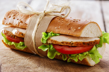 Fototapeta baguette sandwich with grilled chicken and tomatoes obraz