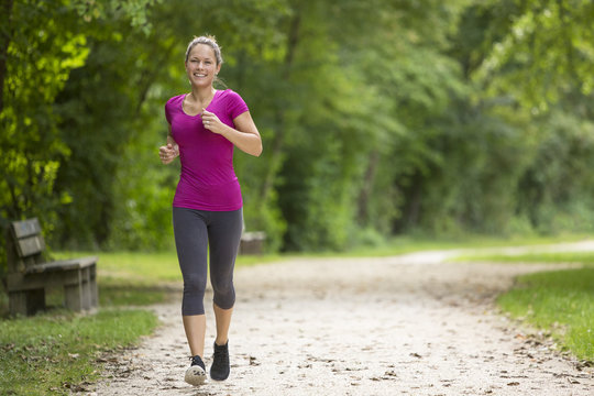 Happy relaxed woman jogging through a park