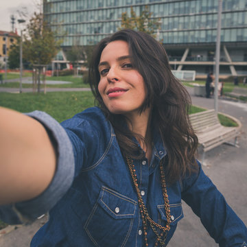 Pretty girl taking a selfie in the city streets