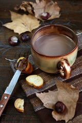Autumn still life: chestnuts, cocoa and chocolate spread on a sl