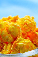 Cheese flavored popcorn in bowl on wooden table