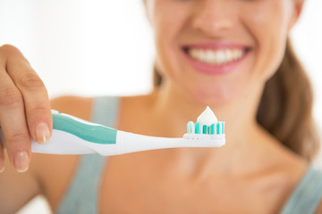 Closeup on young woman showing electric toothbrush