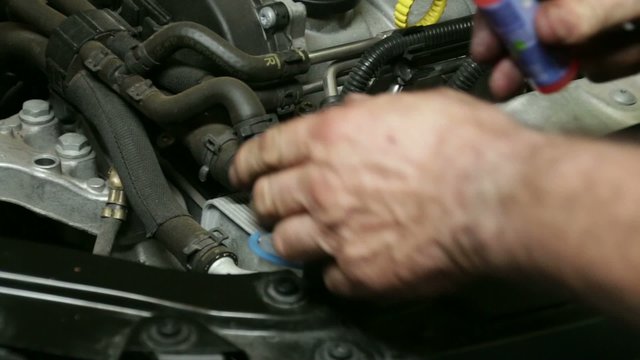 Car Repair Mechanic Filling the Washer Fluid Tank