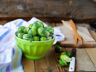 Brussels sprouts in a bowl on a wooden background