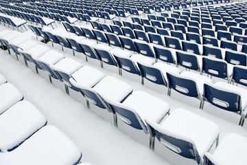 Empty plastic chairs covered in snow
