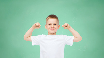 happy little boy in white t-shirt flexing biceps