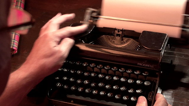 man typing on a typewriter 