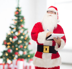 man in costume of santa claus with notepad