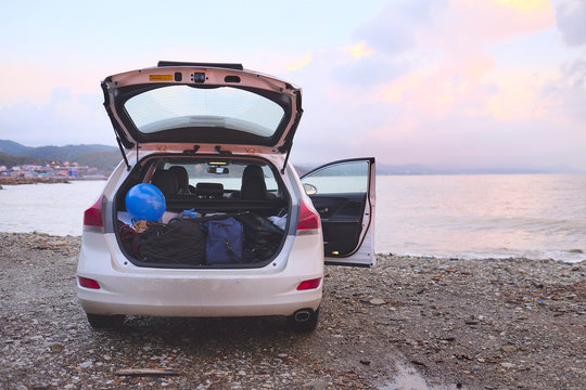 Car with open trunk on a sea coast