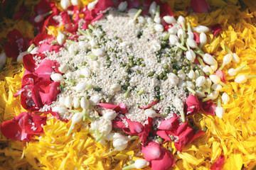 Popped rice and flowers in utensil.