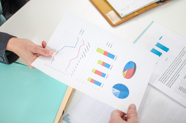 Assistant showing graphs to her boss