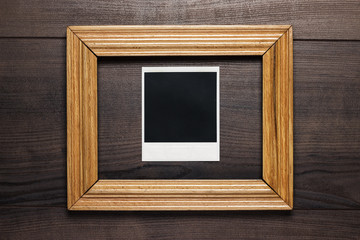 empty frame and old photo on wooden background