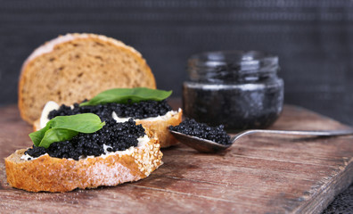 Slices of bread with butter and black caviar