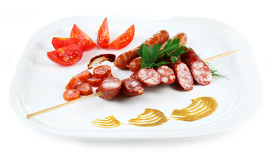 Assortment of tasty thin sausages on plate isolated on white