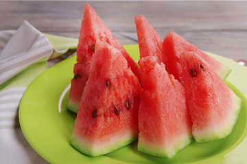 Slices of watermelon on plate on wooden table