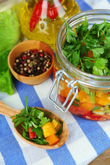 Vegetable salad in glass jar, on  napkin, on wooden background