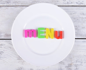 Inscription menu on plate on table close-up