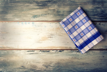 Top view of checkered napkin on old wooden table