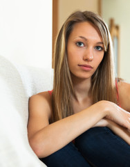 Fototapeta premium Sad girl sitting on couch