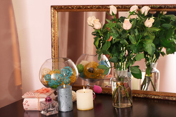 Beautiful vase with roses near mirror