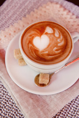 Cup of coffee with cute drawing in cafe