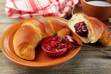 Breakfast with tea and  big fresh croissant on wooden