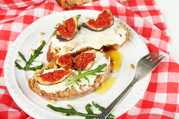 Tasty sandwiches with sweet figs and cottage cheese on plate