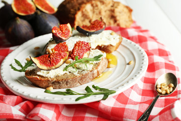 Tasty sandwiches with sweet figs and cottage cheese on plate