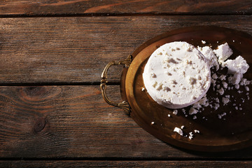 Cottage cheese on metal tray on wooden background