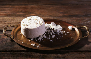 Cottage cheese on metal tray on wooden background